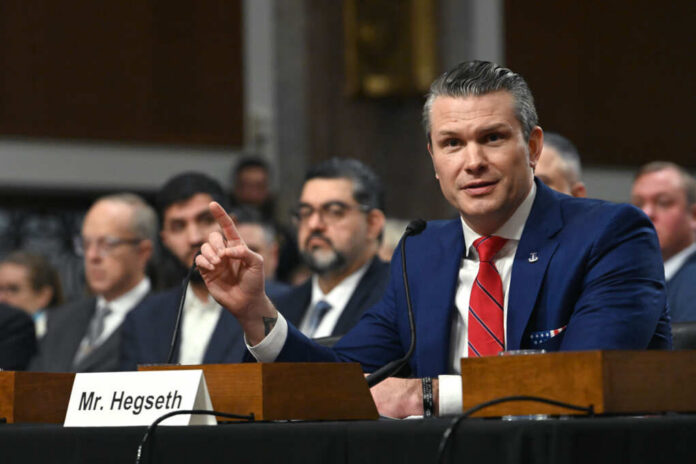 shutterstock_2571781581 A man in a blue suit speaking at a senate hearing with a panel of officials behind him