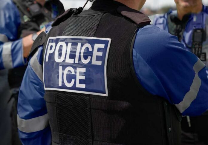 Ice,Police,Agent,-,Officer,Of,Immigration,And,Customs,Enforcement. Close-up of a police officer's vest with 'POLICE ICE' label