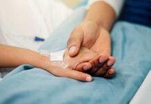 Missed Warnings, Sudden Collapse A patient holding hands with a loved one in a hospital setting