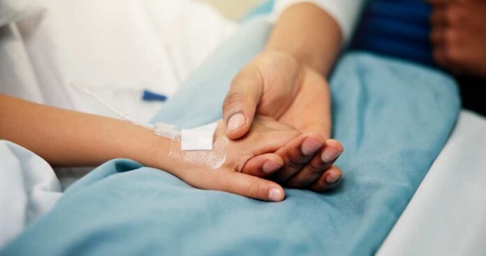 Hospital,,Holding,Hands,And,Parent,With,Child,In,Bed,For A patient holding hands with a loved one in a hospital setting