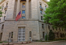 Sex Offender Returns: Judge Drops 46 Months Exterior view of a government building featuring the American flag and decorative entrance