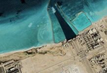 Water War Flashpoint—Gulf on Edge Satellite view of coastal industrial complex with seawater inlet and turquoise shallows