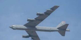 Military bomber aircraft flying against a blue sky