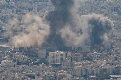 2768830871 Smoke plumes rise over a dense cityscape