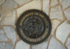 $100B Naval Fiasco Exposed Bronze seal of the Department of the Navy mounted on a stone wall