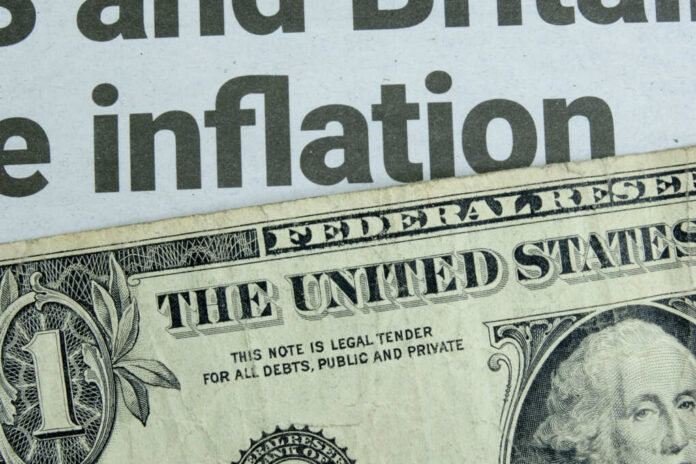 shutterstock2159290149jpg Close-up of a US dollar bill with a newspaper headline about inflation