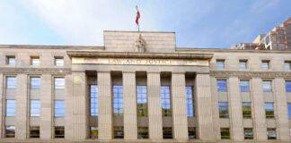 Facade of a government building with the words Law and Justice and a statue on top