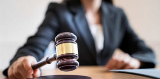 A judges gavel poised above a wooden block on a desk