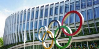Colorful Olympic rings displayed in front of a modern building