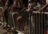 Close-up of hands resting on a barrier in a crowded urban setting