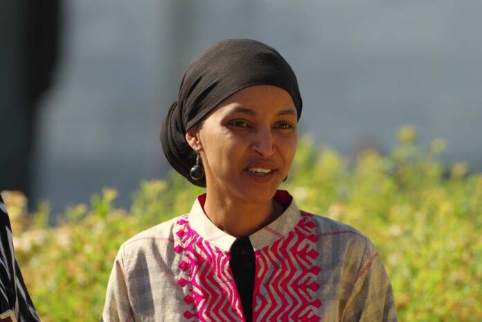 Washington,,Dc,-,May,1,,2024:,U.s.,Rep.,Ilhan,Omar A woman in traditional attire smiling outdoors with greenery in the background