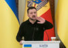 Zelensky’s Purge Sparks Instant Uproar Ukrainian leader speaking at a podium with national flags in the background
