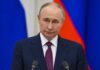 Zelenskyy Dangles Truce; Kremlin Shrugs A serious-looking political figure at a press conference with national flags in the background