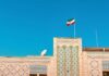 Backchannel Bombshell: U.S. Flags Assassination Risk Building with intricate patterns and the Iranian flag against a clear blue sky