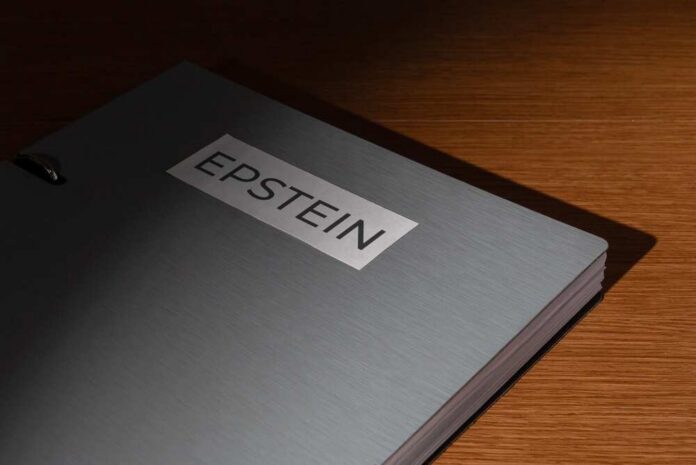 A,File,Folder,Labeled,Epstein,On,A,Wooden,Desk.,Investigations, A metallic folder labeled 'EPSTEIN' resting on a wooden surface