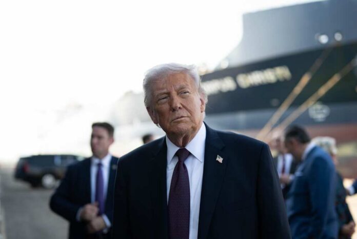 President,Donald,J.,Trump,Delivers,Remarks,On,Energy,At,The A political figure in a suit looking thoughtfully at an outdoor event with a ship in the background