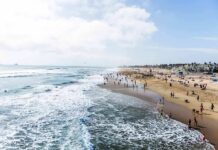 Tropical Swell Turns Beaches Lethal Crowded sandy beach with people by the shoreline