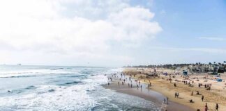 Crowded sandy beach with people by the shoreline