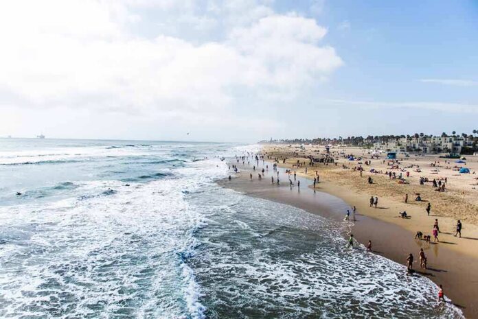 Crowded sandy beach with people by the shoreline