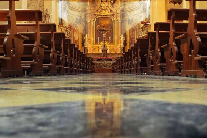 Church interior with wooden pews facing ornate altar