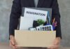 Person holding a cardboard box of office belongings