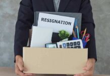 Person holding a cardboard box of office belongings