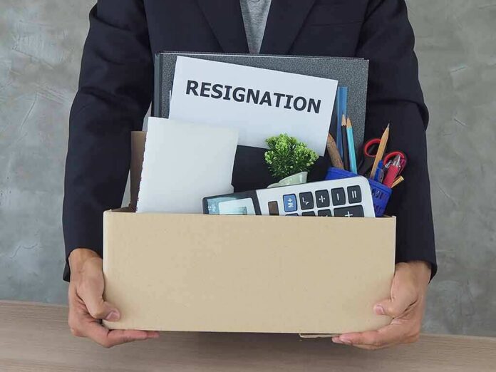 OLYMPUS DIGITAL CAMERA Person holding a cardboard box of office belongings