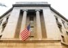 USDA Nepotism Scheme Exposed American flag hanging on a neoclassical government building