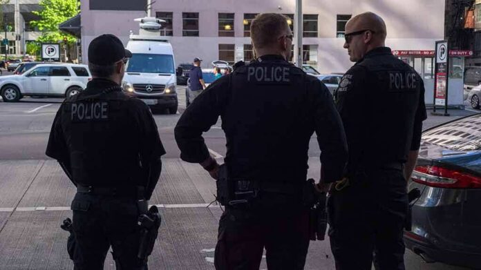Police officers stand on a city street