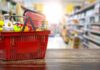 ID Uproar Erupts Over NYC Grocery Plan Red shopping basket filled with groceries on a store aisle