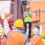 construction workers raising fists during a safety briefing