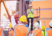 Border Brawl Hits Michigan Paychecks construction workers raising fists during a safety briefing