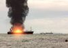 Cargo Ship Downed — Who Pulled Trigger? Cargo ship on fire with thick black smoke at sea