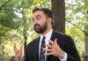 Hacked Files Ignite Columbia Identity Firestorm Man in a suit gesturing while speaking outdoors