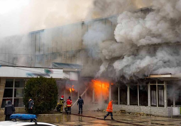 shutterstock_404947000 firefighters respond to large building fire with heavy smoke