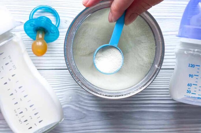 shutterstock_604264955-1 Baby formula powder in a can with a blue scoop