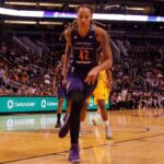 Olympic Icon Torches WNBA’s ‘Woman’ Gap basketball player dribbling on a court during a game