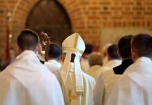 Church Civil War Erupts Over Divorce Bishop in white mitre among clergy during church procession