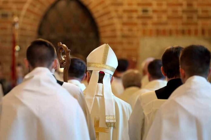 shutterstock_653291812 Bishop in white mitre among clergy during church procession