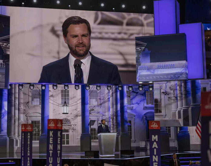 2490670425 Man speaking at podium on stage, projection behind him.