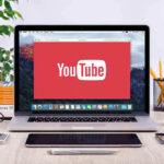 Defamation Hammer Poised Over Influencers YouTube logo on a laptop screen on desk.