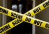 Yellow crime scene tape crossing a doorway