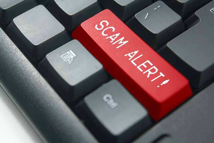 shutterstock_1013735752 Keyboard with red scam alert key