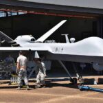 Air Force Embraces Loss-Tolerant Drones Military drone being serviced by ground crew outside a hangar