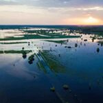 Himalayan Downpours Turn Deadly Aerial view of flooded farmland at sunset