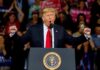 Rare GOP Rebuke Hits Trump’s Immigration Push Donald Trump speaking at a rally podium with arms raised