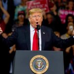 Rare GOP Rebuke Hits Trump’s Immigration Push Donald Trump speaking at a rally podium with arms raised