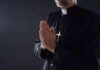 Cardinal’s Call Sparks Fury in Chicago Clergyman in black robe praying with hands together