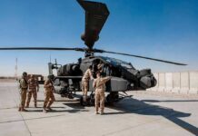 Billion-Dollar Laser Bet Sparks Pentagon Uproar Soldiers inspect a military attack helicopter on a tarmac