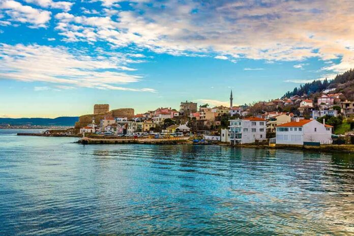 shutterstock_1273413490 Coastal town with waterfront houses and a historic fortress